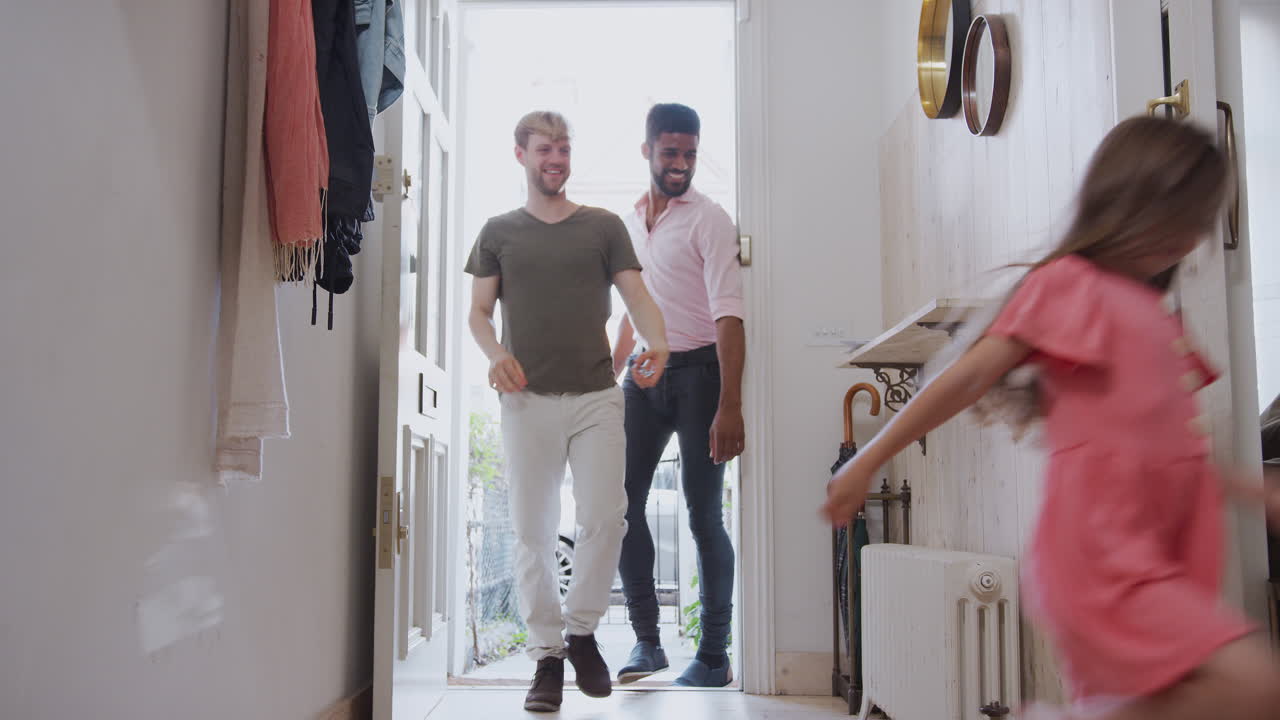 동성 남성 커플과 딸이 집 앞 문을 열고 복도 안을 보십시오.