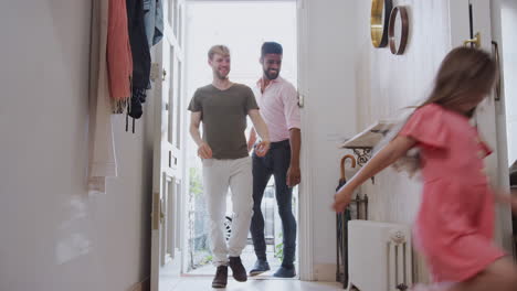 view inside hallway as same sex male couple with daughter open front door of home