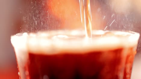 Cola-with-splashing-bubbles-slow-motion-on-a-blurry-light-,blurry-background.