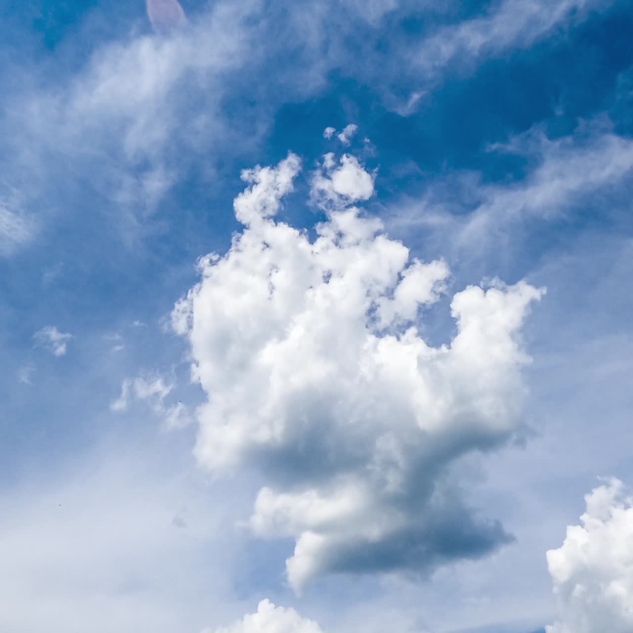 Beautiful fluffy clouds changing shape in the sky. Soft cloudscape in the rays of bright sun timelapse