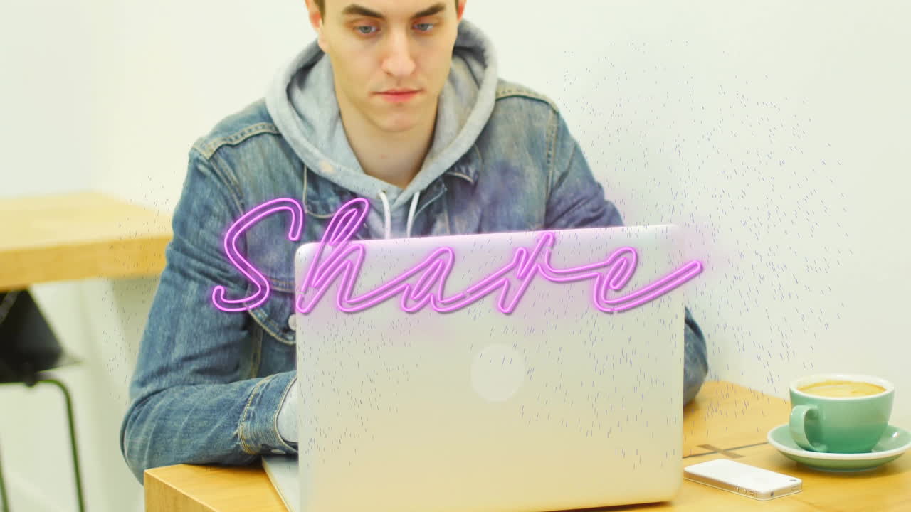 Male worker typing on laptop in coworking space, showing neon pink Share overlay for technology