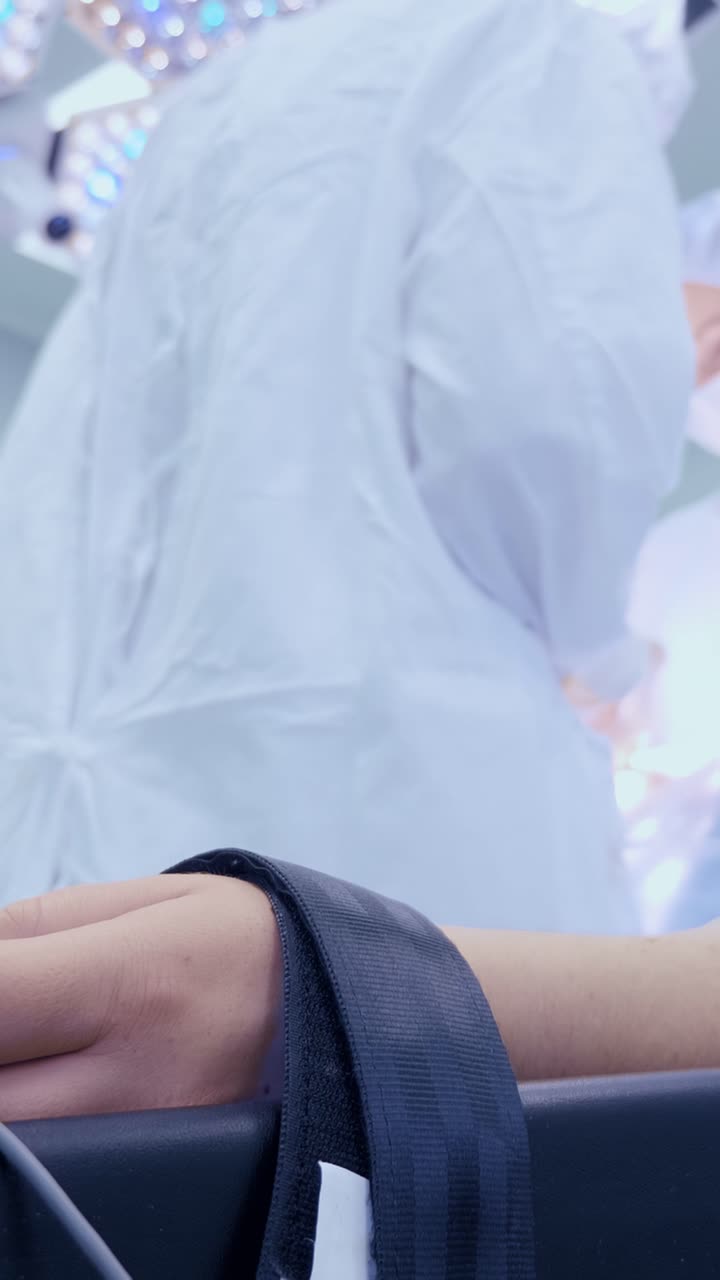Patient's hand with medical equipment in a sterile environment during a surgical procedure