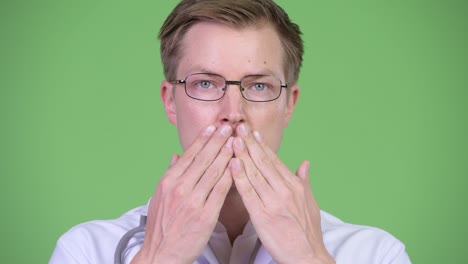 portrait of young man doctor covering mouth