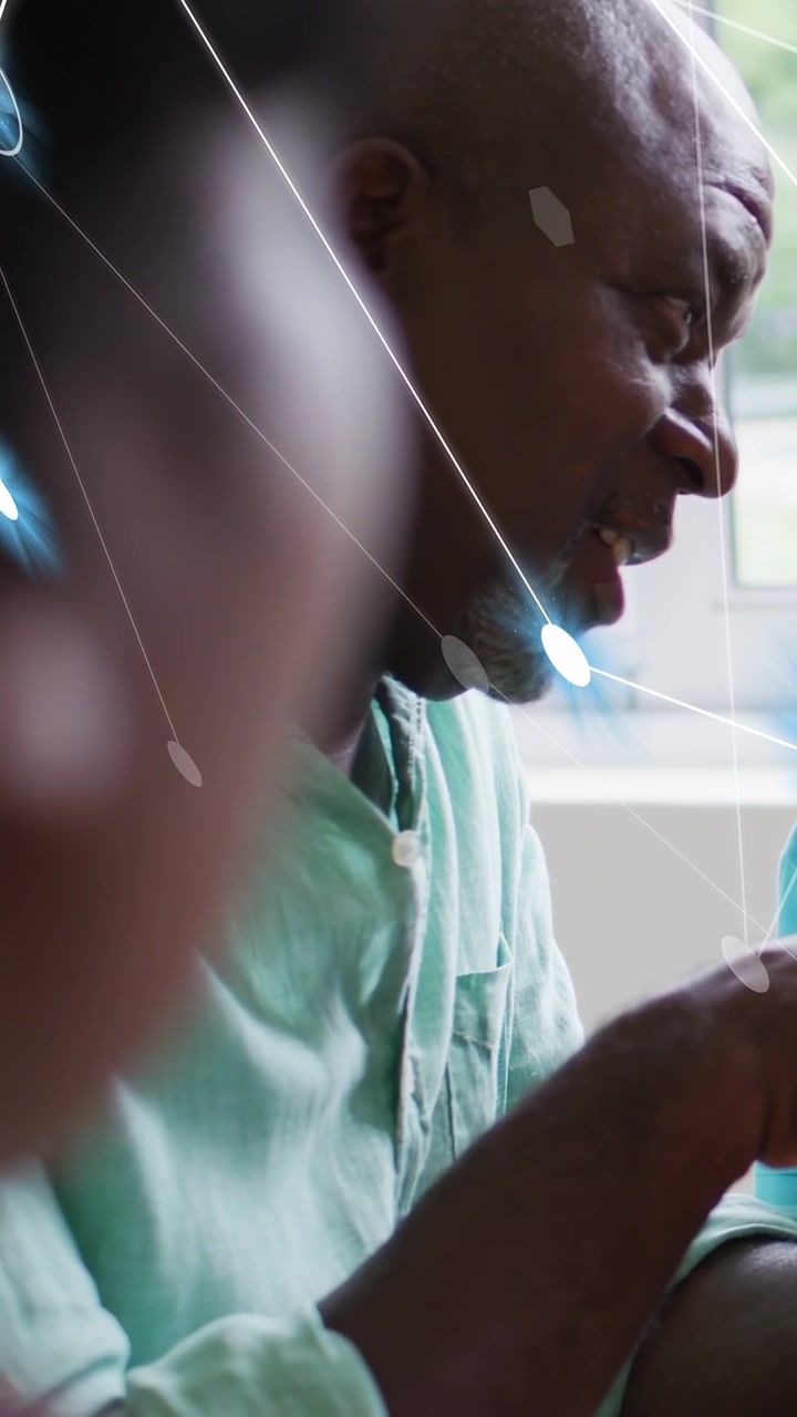 Vertical video: Senior man with child offering cup and talking by window, nodes appearing, teaching