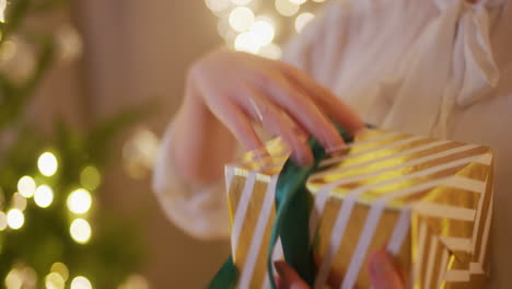 woman opens a present unpacks a golden present