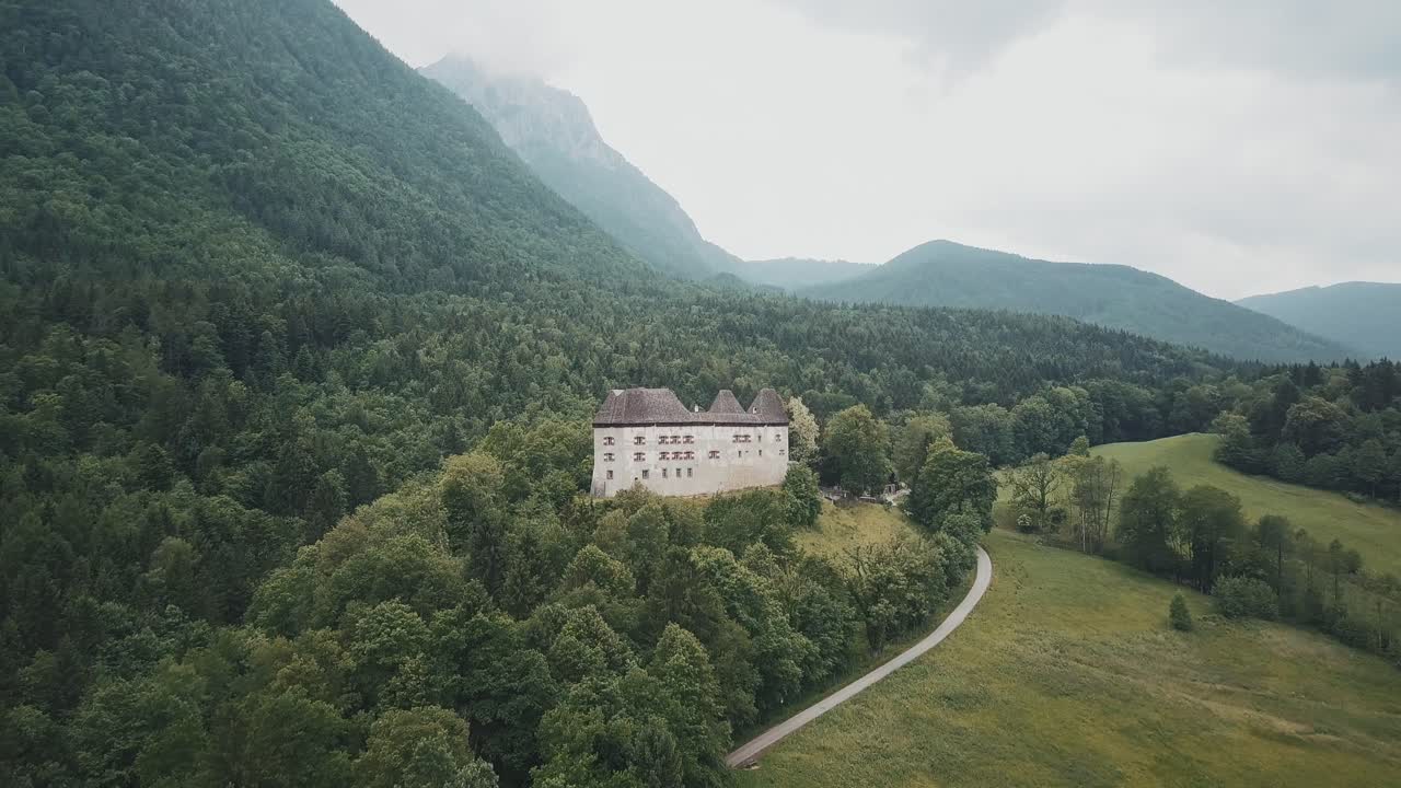 toma de drones de un palacio alemán cerca de un bosque y montañas en pidingerau, alta baviera, alemania, en un día nublado, brumoso y malhumorado
