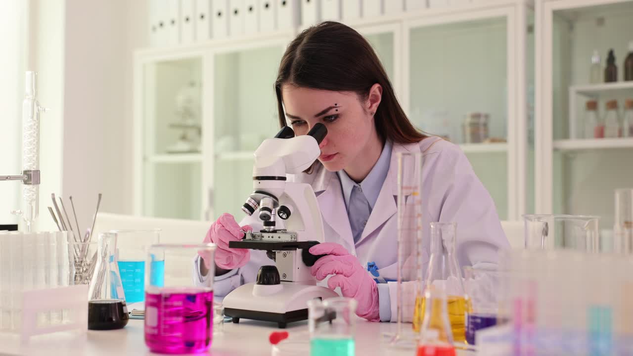 Científico trabajando con microscopio en laboratorio.