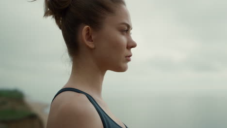 Sportswoman-looking-ahead-standing-beach-closeup.-Girl-making-breathing-exercise