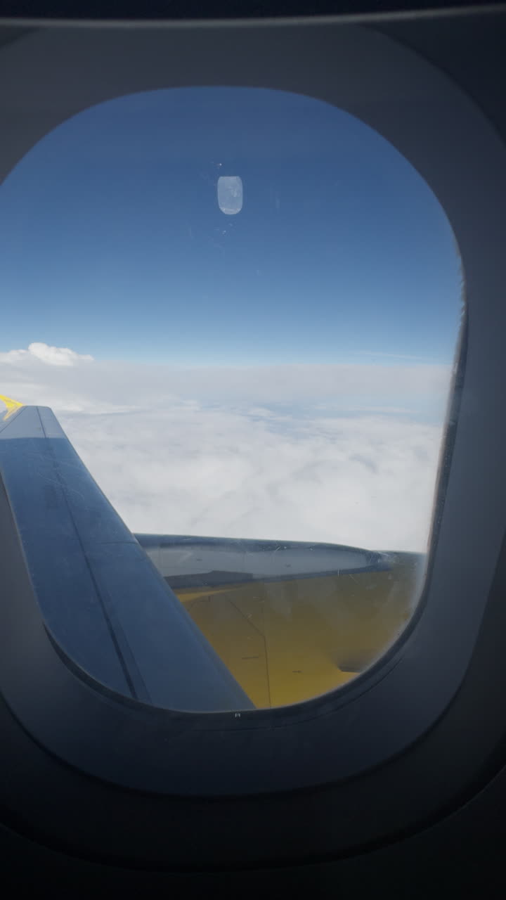 수직으로  된 비행기의 날개와 함께 하늘의 비행기 창문에서 볼 수 있습니다.
