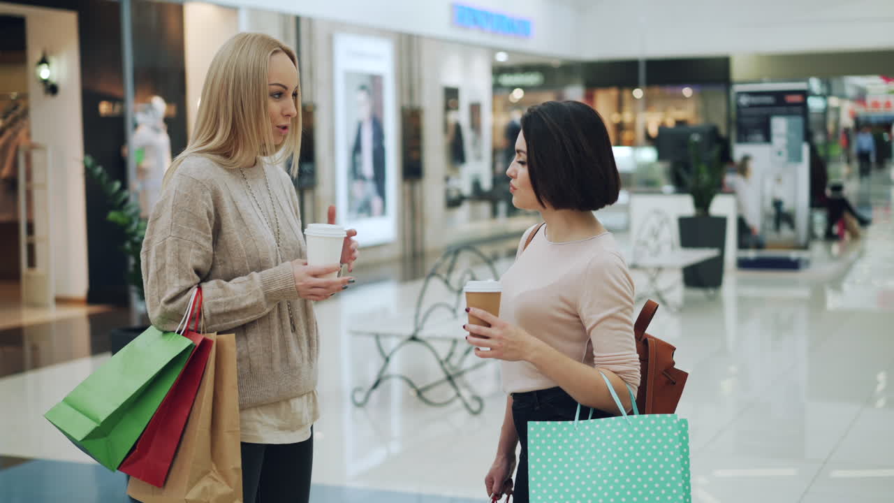 Two women shopping and talking in a mall