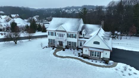 american house with snow-covered grass in garden