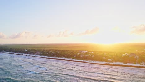 drone flying over ocean waves near mexican beach during gorgeous golden caribbean sunset.