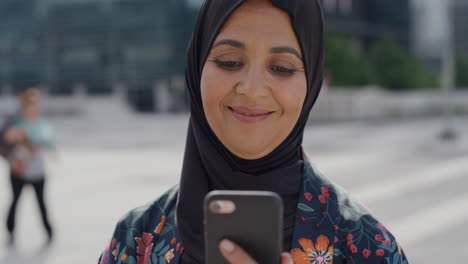 Primer-Plano-Retrato-De-Una-Mujer-Musulmana-De-Mediana-Edad-Usando-Un-Teléfono-Inteligente-En-La-Ciudad-Disfrutando-Leyendo-Mensajes-En-Línea-Enviando-Mensajes-De-Texto-En-Un-Teléfono-Móvil-Estilo-De-Vida-Urbano-Moderno