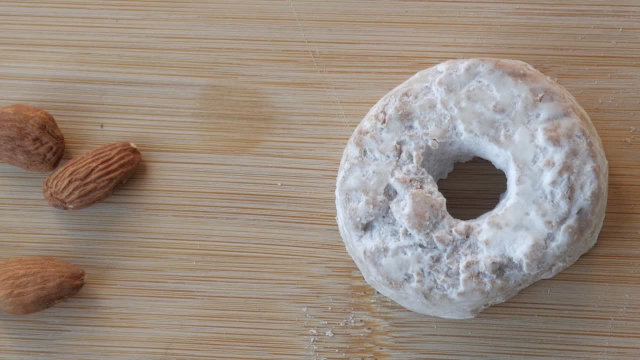 Panning view of almonds, rosco de vino and butter on a wood table. Close-up. traditional Spanish sweet.