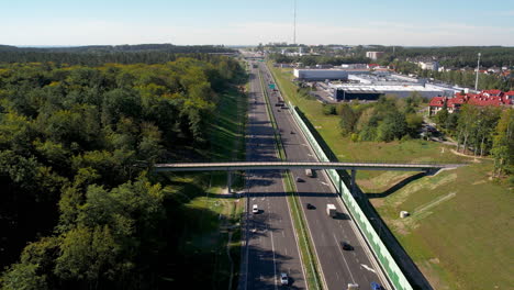 Aerial-shots-of-a-bustling-highway-intersection-surrounded-by-lush-greenery-and-urban-infrastructure