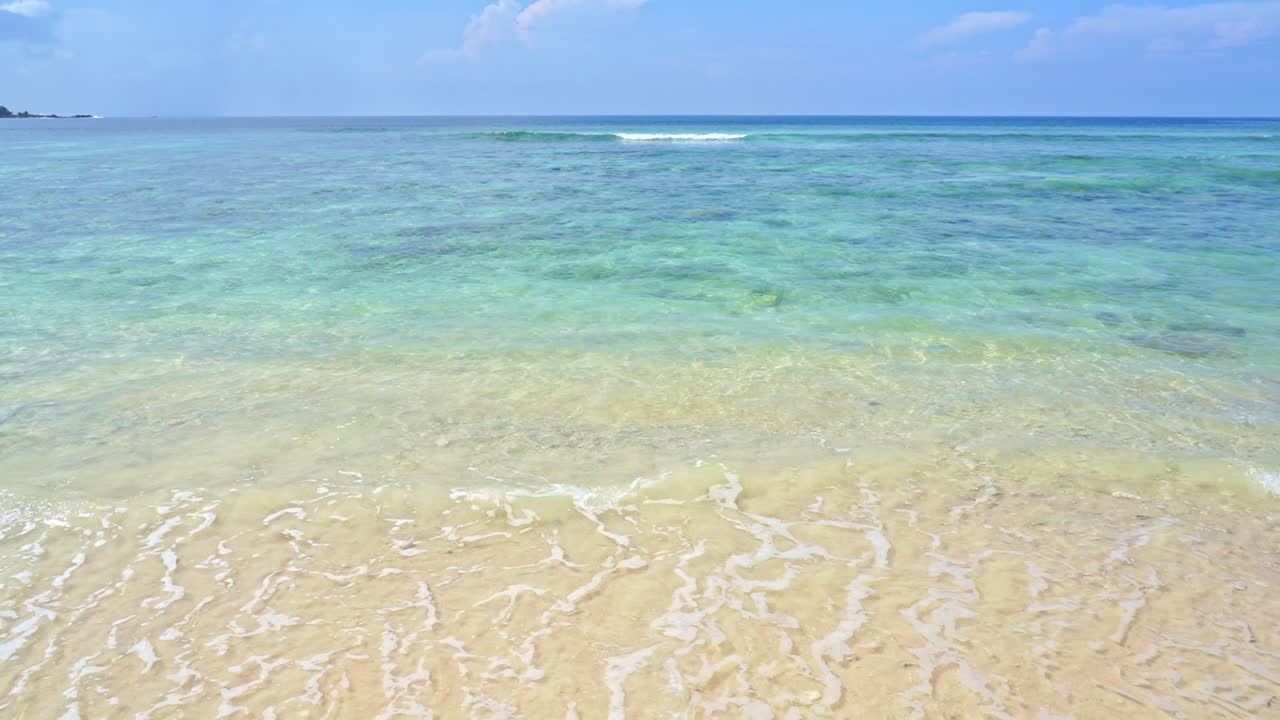 파도가 깨끗한 모래 해변을 씻다