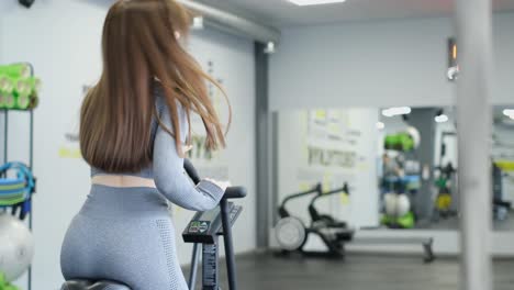 active woman spinning air bike in gym brunette female training on air bike in slow motion f active woman spinning air bike in gym brunette female training on air bike in slow motion fitness girl working in gym