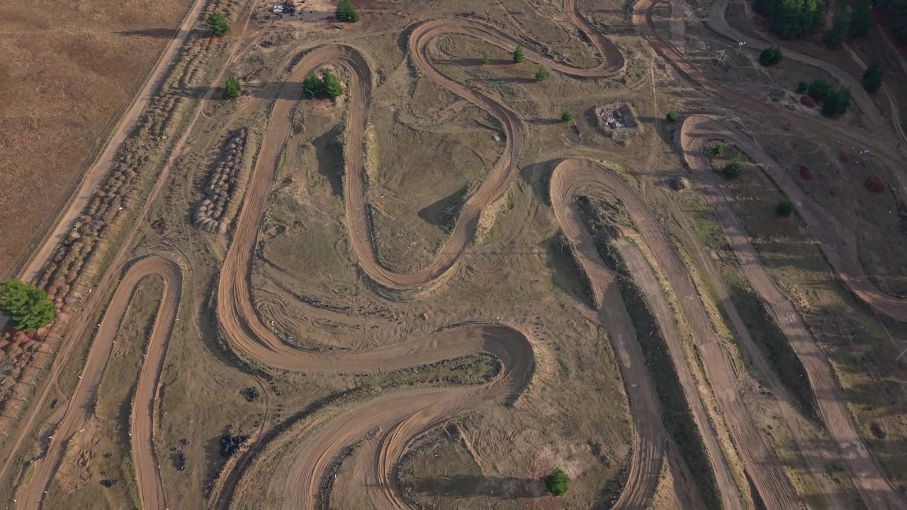 Drohnen-Luftaufnahmen der Motocross-Strecke des Central Otago Motorcycle Club in Cromwell, Neuseeland, mit kurvigen Erdpisten, Sprüngen, Anliegern und Offroad-Fahrgelände