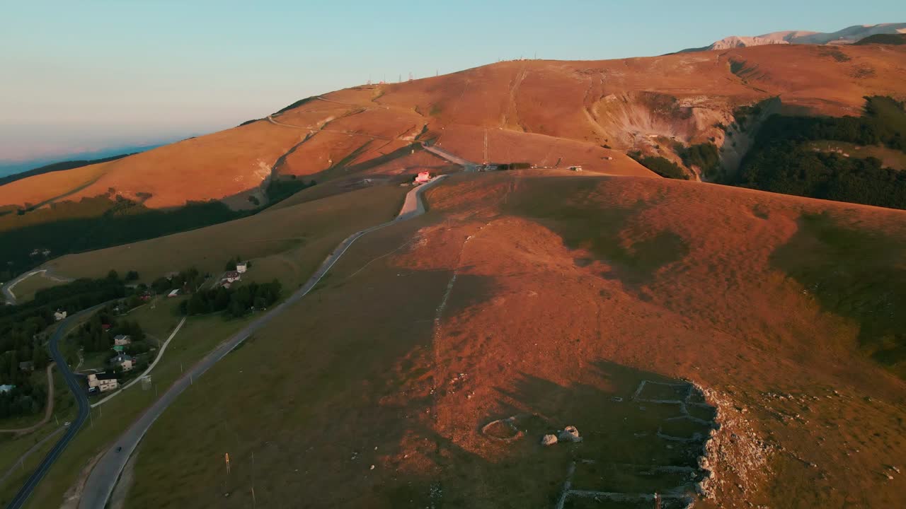 Road Leading To The Ski Lifts Immersed In The Mountains Of Majella National Park On Beautiful Morning Of August. Sunlight Illuminating The Landscape. - Aerial Drone Shot