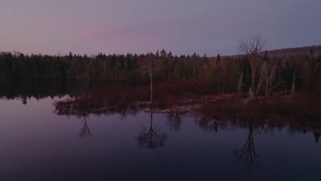 Trees-reflected-in-the-still-water-across-Monson-Pond