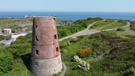 amlwch port red brick disused abandoned windmill aerial view north anglesey wales close orbit left