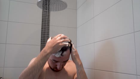 Gleitaufnahme-Eines-Mannes,-Der-Sich-In-Der-Dusche-Die-Haare-Mit-Shampoo-Wäscht