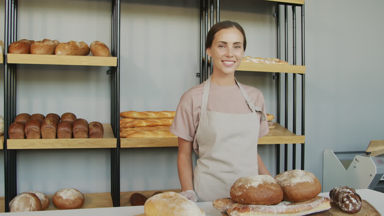 Dipendente felice di una panetteria sorride alla fotocamera