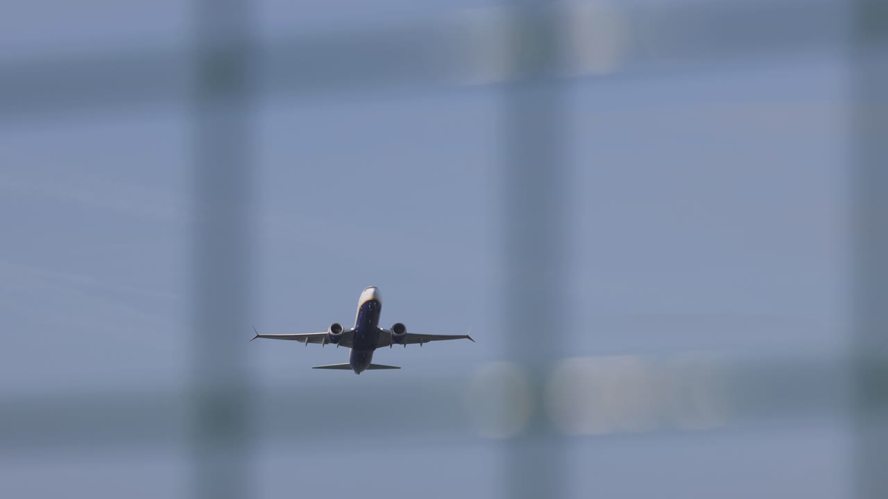 Airplane taking off in Porto airport with fence. Slow motion shot