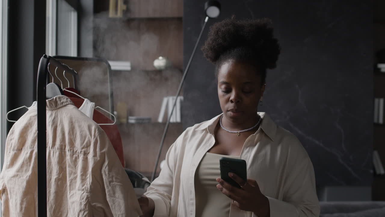 Woman steaming clothes using a garment steamer