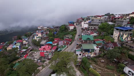 imágenes aéreas de la ciudad de baguio en un día gris y sombrío, con cielos nublados, edificios y vegetación exuberante