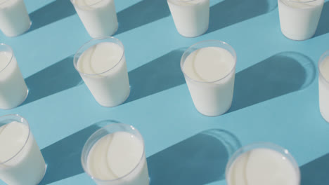 Video-of-row-of-glasses-of-milk-on-blue-background