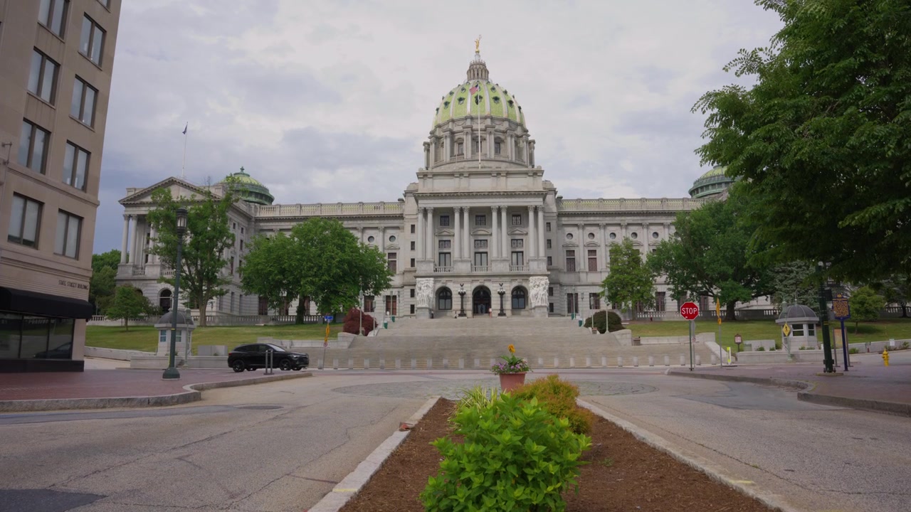 Tomada em dolly ascendente revelando o Capitólio Estadual da Pensilvânia em Harrisburg, Pensilvânia, destacando a arquitetura governamental histórica, o design cívico e um proeminente marco estadual