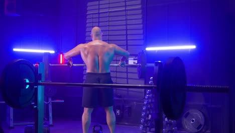 man lifting barbell in a gym