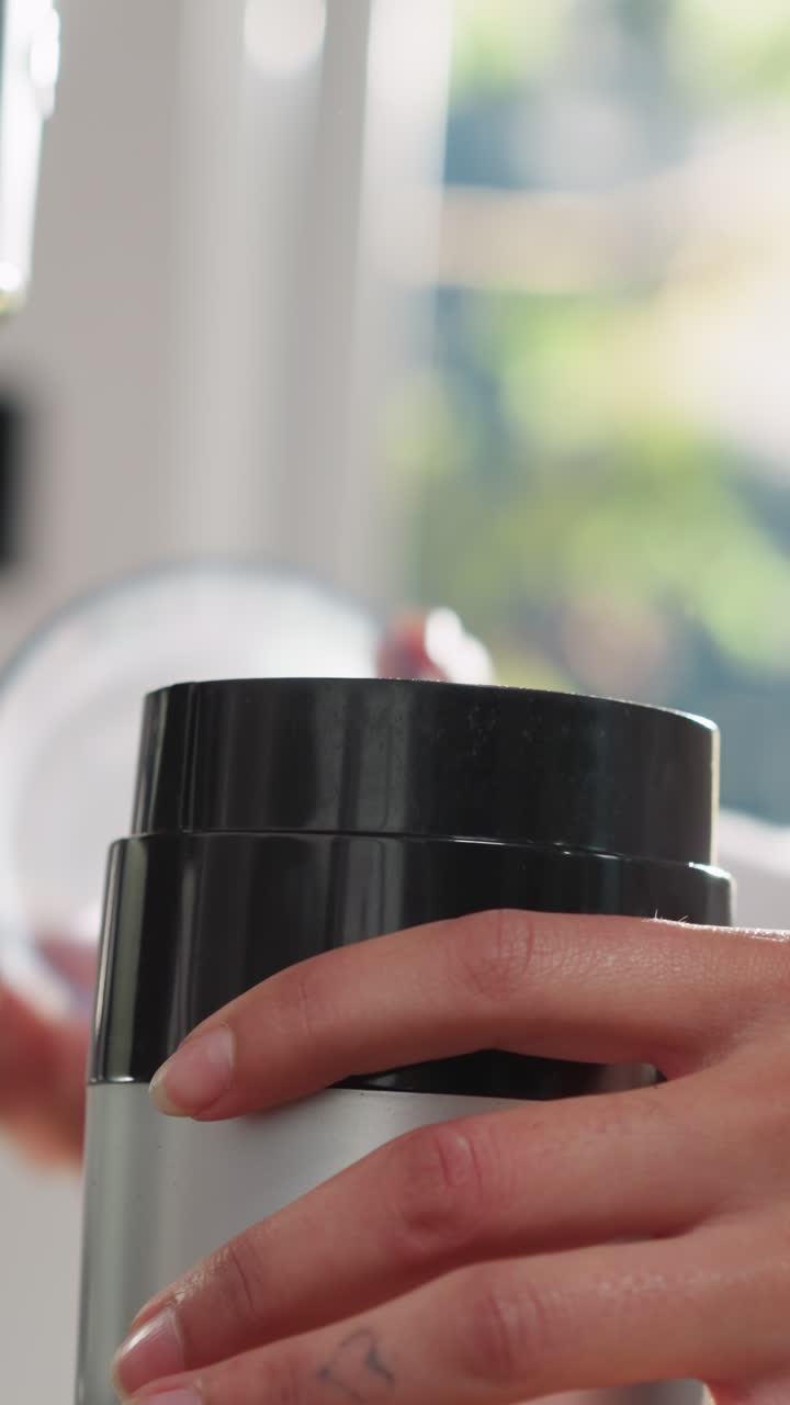 여성은 부에서 커피 밀러를 열고, 집에서 에너지 음료를 만드는 데 현대적인 가전제품을 사용합니다. 쉽고 빠른 요리