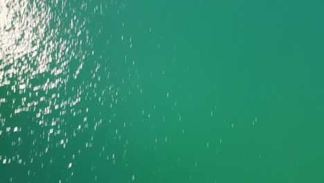 Dron flying forward slowly from lake revealing snow mountain landscape