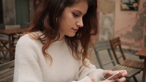 happy young woman chatting on her smartphone outdoors