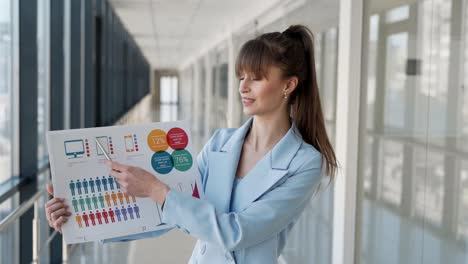 close-up of a woman in a business suit showing on a slide with infographics looking at the camera