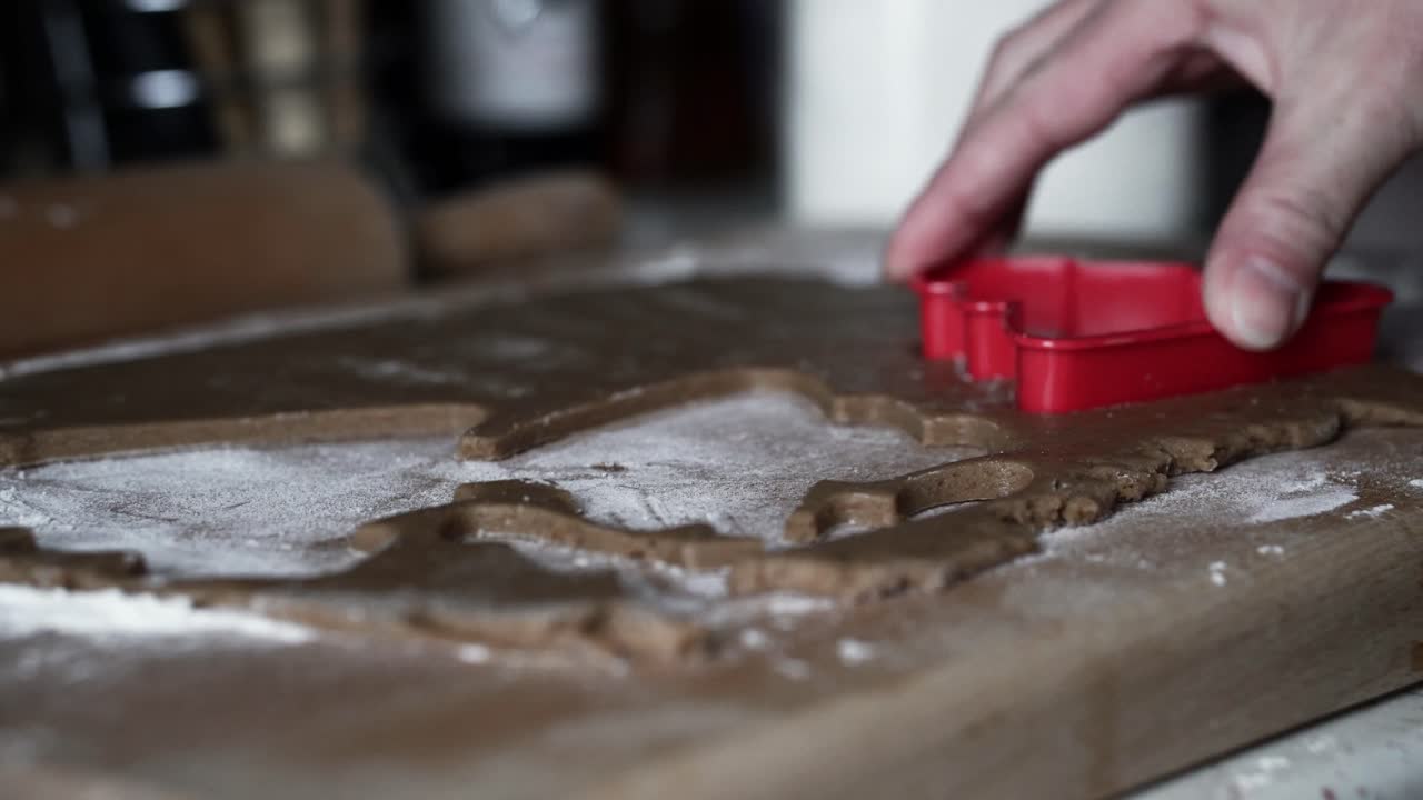Kvinne av kaukasisk opprinnelse som lager treformede pepperkaker.