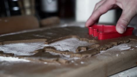 caucasian female making tree-shaped gingerbread cookies