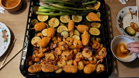 una deliciosa variedad de mariscos y verduras a la parrilla con salsas de inmersión en una mesa