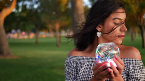 una hermosa gitana sosteniendo una mágica bola de cristal brillante con una mirada encantadora y misteriosa