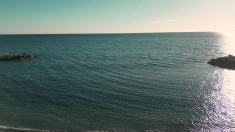 calm malaga beach at sunset with gentle waves and clear skies, reflecting serenity