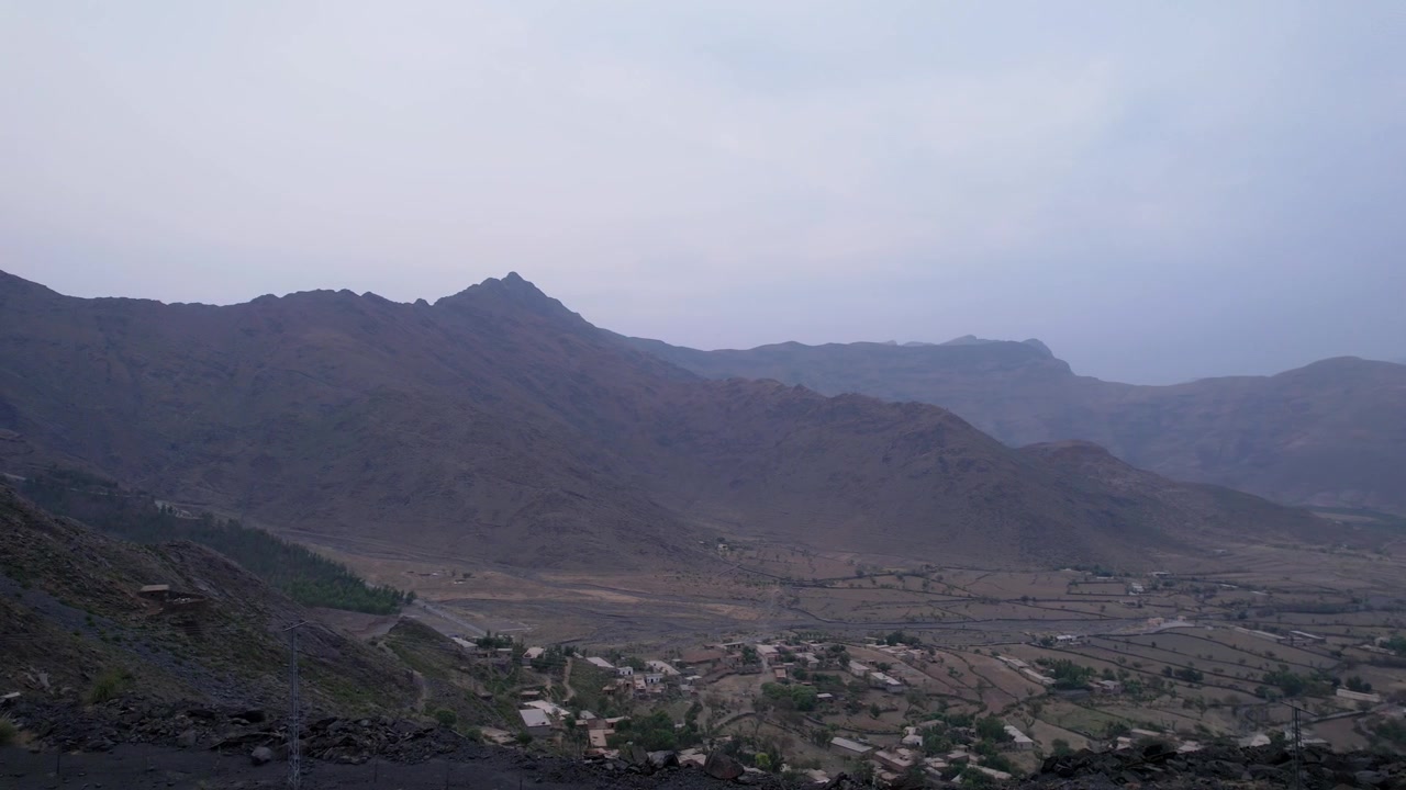 Un insediamento rurale si estende attraverso un'ampia valle sotto montagne rocciose ad Alladhand Dheri, Chakdara, Khyber Pakhtunkhwa, Pakistan