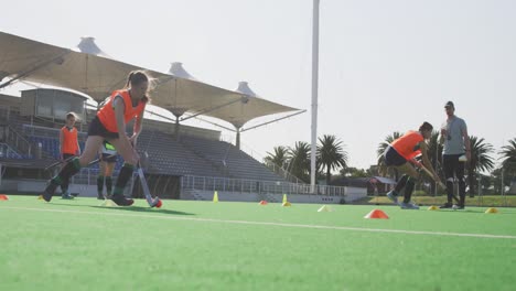 jugadoras de hockey entrenando en un campo