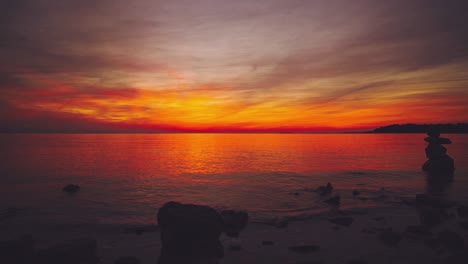el tiempo de la puesta de sol sobre el horizonte en una pintoresca playa de agua tranquila natural romántica con pequeñas olas en la costa mediterránea croata como una bola grande y naranja. vacaciones de turismo al aire libre puesta de sol cinemagraph bucle de video sin fisuras im 4k uhd.