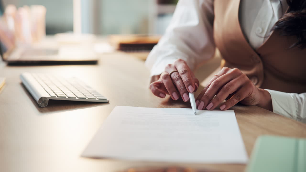Woman signing a document at her desk