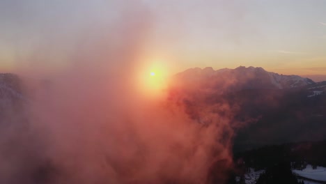 glorious sunset through clouds over mountain range at rolle pass, dolomites