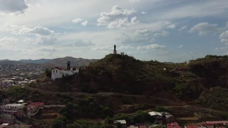 frontal drone shot of a mine in el parral chihuahua, mexico, discovering the city in the background