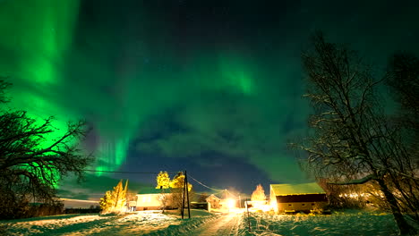 timelapse of green northern lights in starry sky in winter over houses in norway