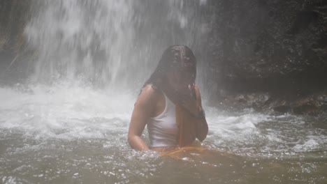 a young woman with long, dark hair is dancing in the water with a yellow piece of fabric in slow motion